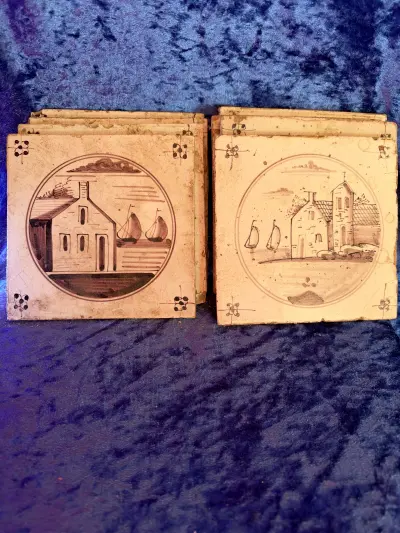 8 stk forskellige håndmalede hollandske kakler fra 1700- eller 1800-tallet med et karakteristisk hus- og bådmotiv i manganfarve.
