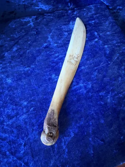 Brevåbner i ben. Genstanden ser ud til at være en traditionel samisk brevkniv lavet af ben eller renhorn, ofte dekoreret med scrimshaw-graveringer af f.eks. et rensdyr